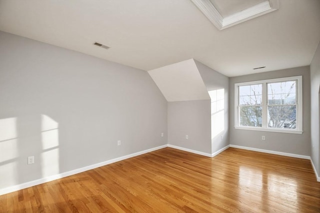 additional living space with vaulted ceiling and light hardwood / wood-style floors