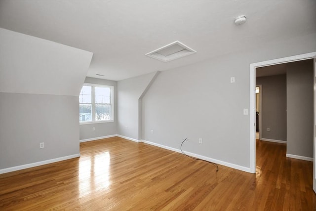 additional living space featuring lofted ceiling and hardwood / wood-style floors