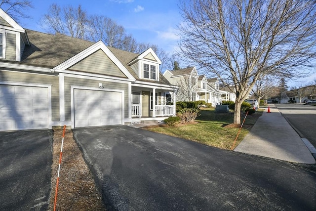 cape cod home featuring covered porch and a garage