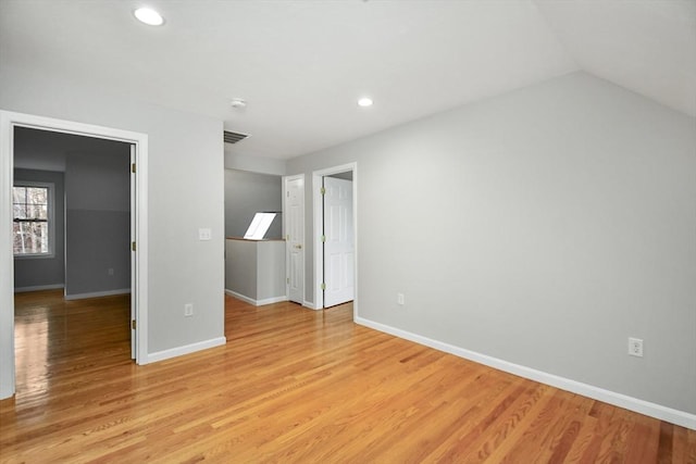 interior space featuring light wood-type flooring and vaulted ceiling