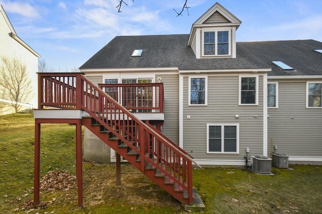 rear view of house featuring a lawn, a deck, and central AC unit