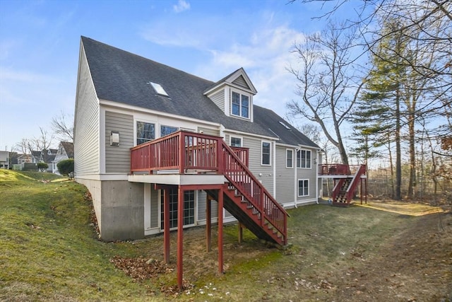 rear view of house featuring a deck and a yard