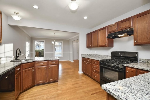 kitchen featuring light stone countertops, light hardwood / wood-style flooring, a chandelier, black appliances, and sink