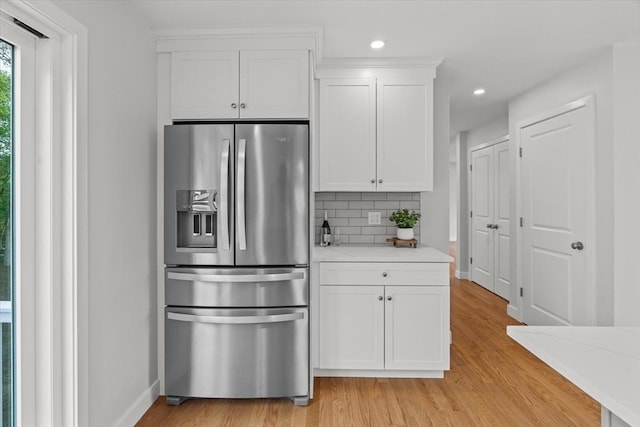 17 Upland Rd, Lynn, MA 01902 - kitchen featuring stainless steel fridge, light wood-type flooring, backsplash, light countertops, and white cabinetry
