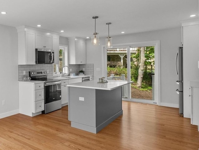 17 Upland Rd, Lynn, MA 01902 - kitchen with stainless steel appliances, light countertops, backsplash, light wood-style floors, and recessed lighting