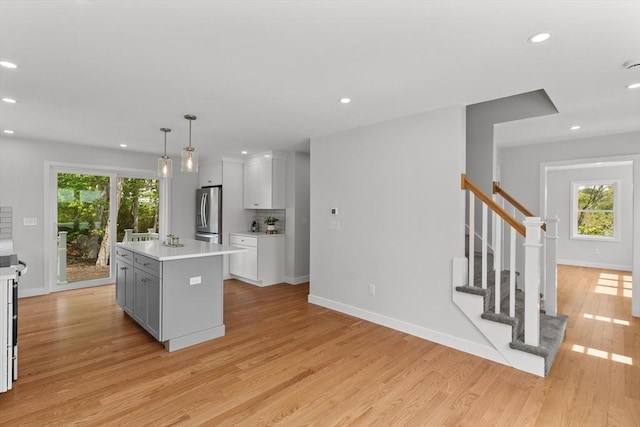 17 Upland Rd, Lynn, MA 01902 - kitchen featuring freestanding refrigerator, light wood-style floors, a kitchen island with sink, light countertops, and recessed lighting