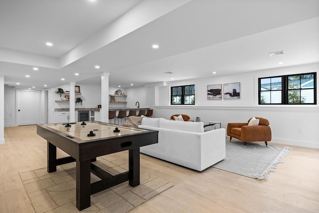 game room featuring recessed lighting, a healthy amount of sunlight, baseboards, and light wood finished floors