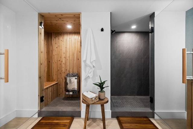 bathroom featuring wooden walls, recessed lighting, a walk in shower, and wooden ceiling