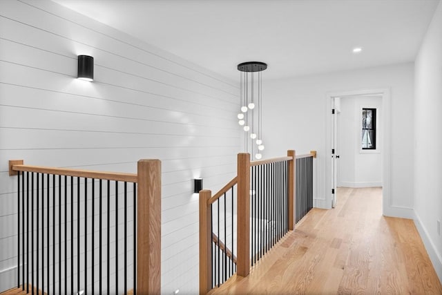 hallway with recessed lighting, baseboards, an upstairs landing, and light wood-style flooring