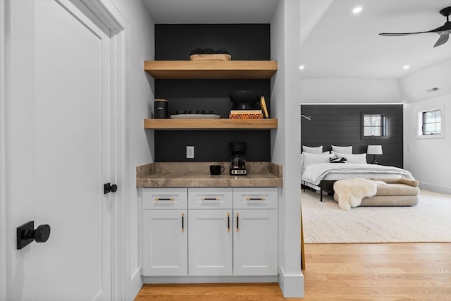 bedroom featuring light wood-type flooring, baseboards, visible vents, and a ceiling fan