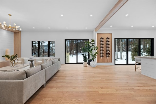 living area with a notable chandelier, recessed lighting, light wood-style flooring, and beamed ceiling