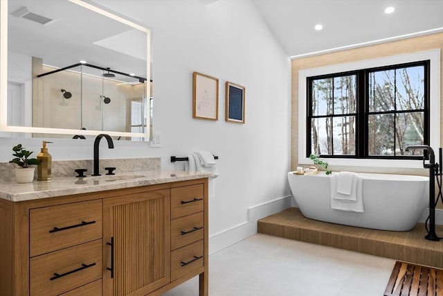 bathroom with vanity, baseboards, visible vents, a soaking tub, and a shower stall