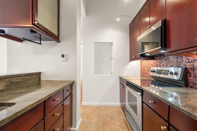 567 Tremont St Unit 20, Boston, MA 02118 - kitchen with stainless steel appliances, decorative backsplash, dark stone counters, and light tile patterned floors