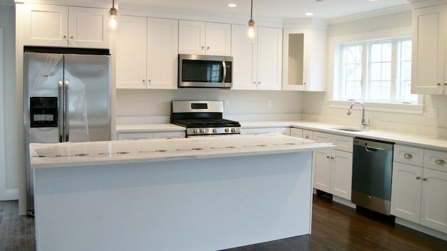 2 Mitchell Ln Unit B, Weymouth, MA 02190 - kitchen featuring appliances with stainless steel finishes, white cabinetry, crown molding, dark wood finished floors, and a center island