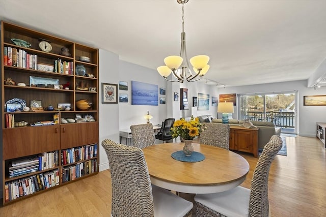 dining room featuring light wood-type flooring and a chandelier