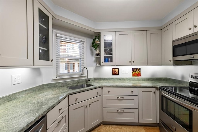 kitchen featuring sink, stainless steel appliances, and gray cabinetry