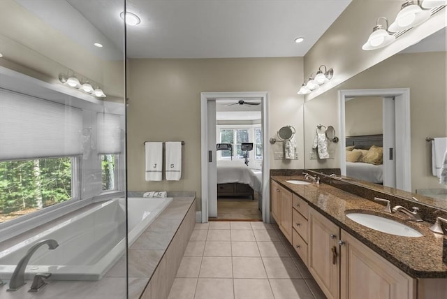 bathroom featuring tiled bath, a wealth of natural light, vanity, and tile patterned floors