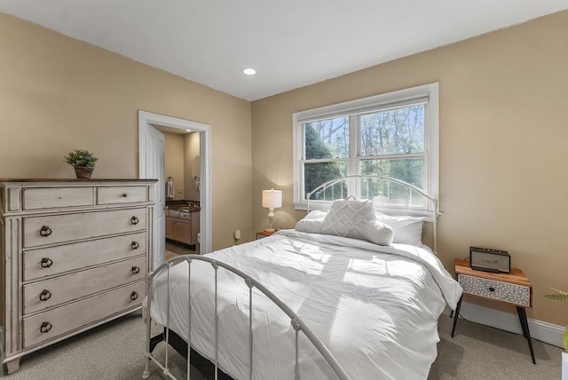 bedroom with ensuite bathroom and carpet flooring