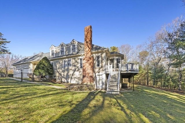 view of side of property with a lawn, a deck, and a garage