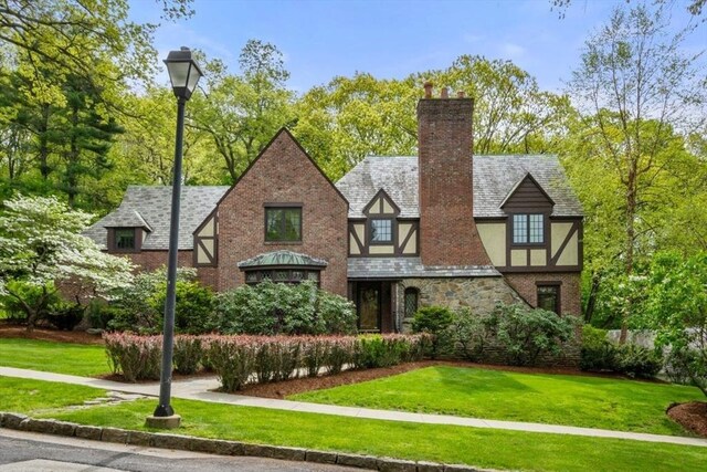 tudor-style house featuring a front yard