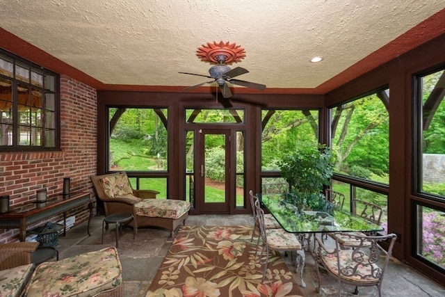 sunroom / solarium featuring plenty of natural light and ceiling fan