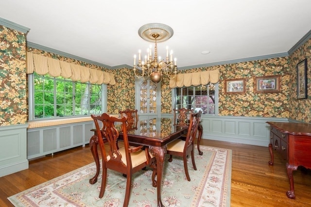 dining space featuring crown molding, a notable chandelier, radiator heating unit, and wood-type flooring