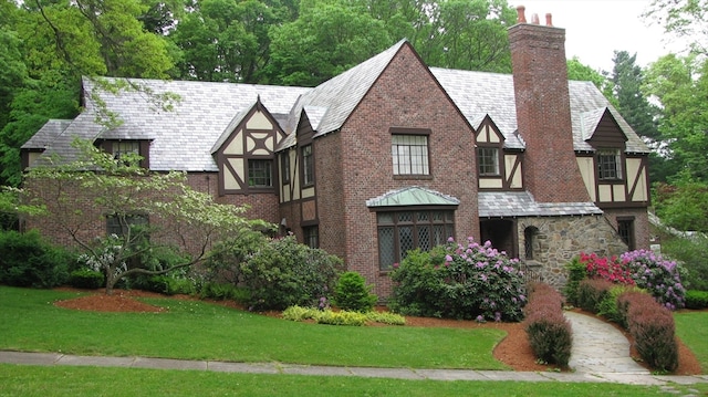 tudor home with a front lawn