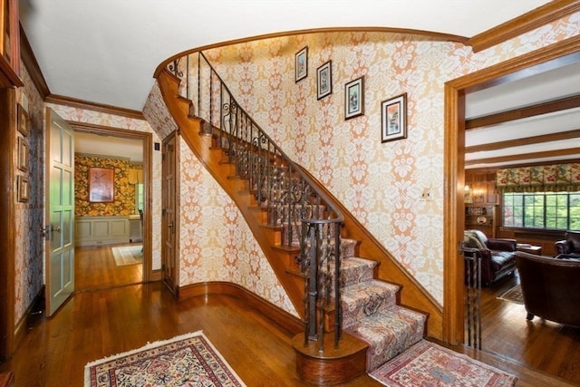 stairway with hardwood / wood-style flooring and crown molding