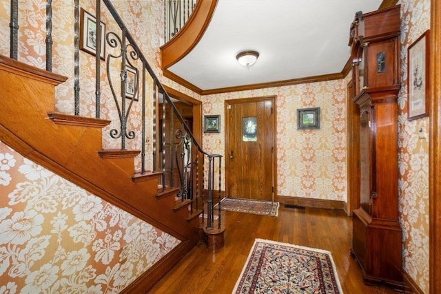 entryway featuring ornamental molding and dark hardwood / wood-style floors