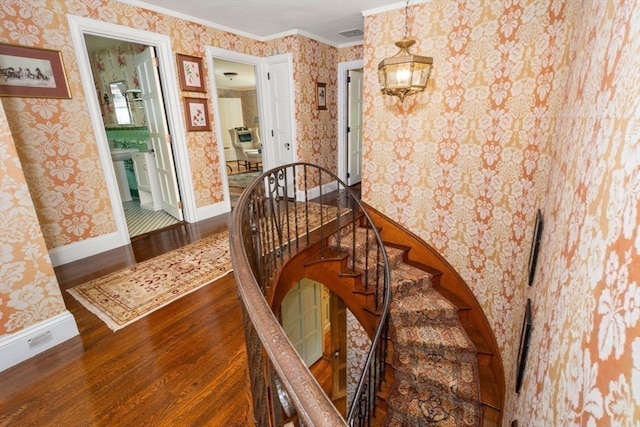 staircase featuring hardwood / wood-style flooring and ornamental molding