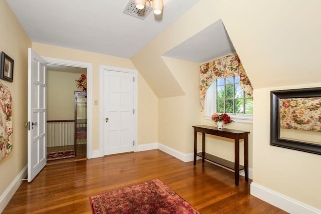 additional living space featuring vaulted ceiling and dark hardwood / wood-style floors