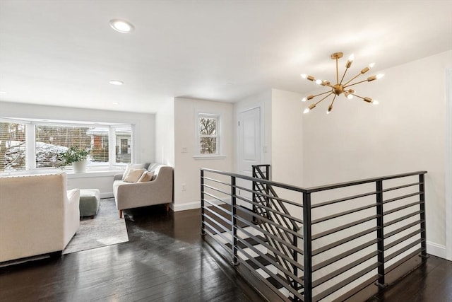 stairway featuring hardwood / wood-style flooring and a notable chandelier