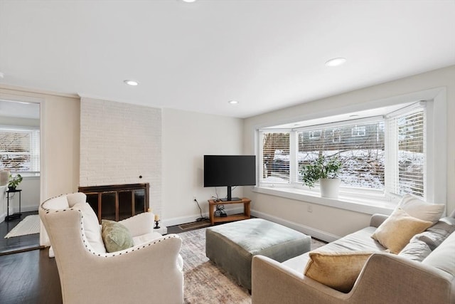 living room with hardwood / wood-style floors and a brick fireplace