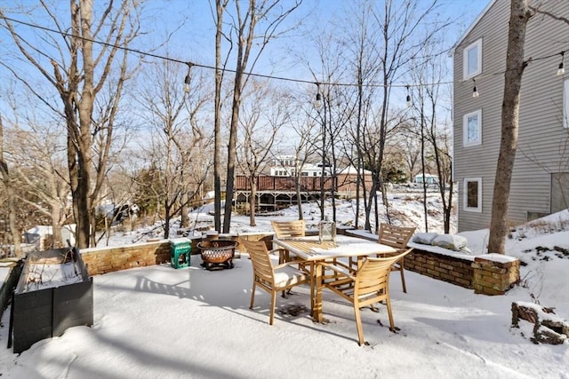 snow covered patio featuring a fire pit