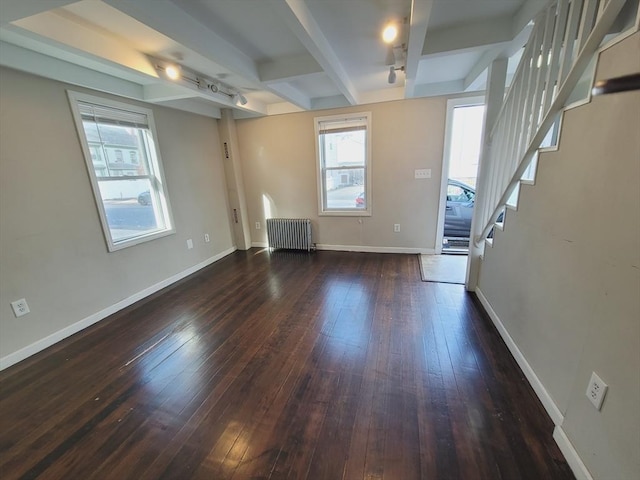 spare room with beamed ceiling, dark hardwood / wood-style floors, and radiator heating unit