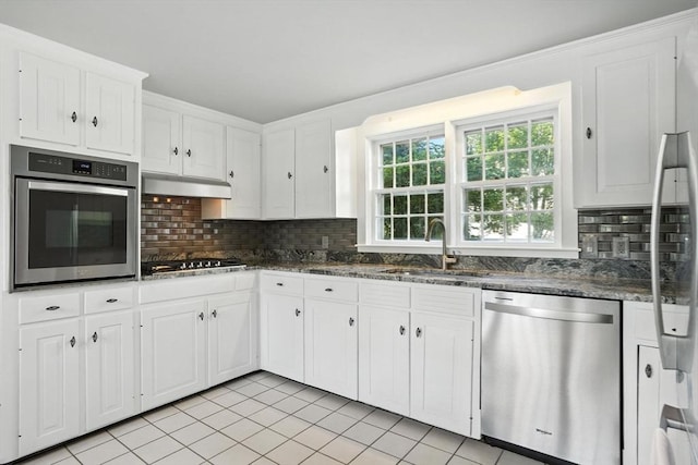 14 Wadsworth Ln, Duxbury, MA 02332 - kitchen featuring appliances with stainless steel finishes, light tile patterned flooring, white cabinetry, and tasteful backsplash