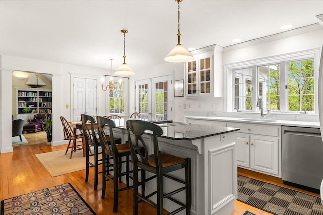 151 River Rd, West Newbury, MA 01985 - kitchen with stainless steel dishwasher, a sink, a kitchen bar, a center island, and white cabinetry