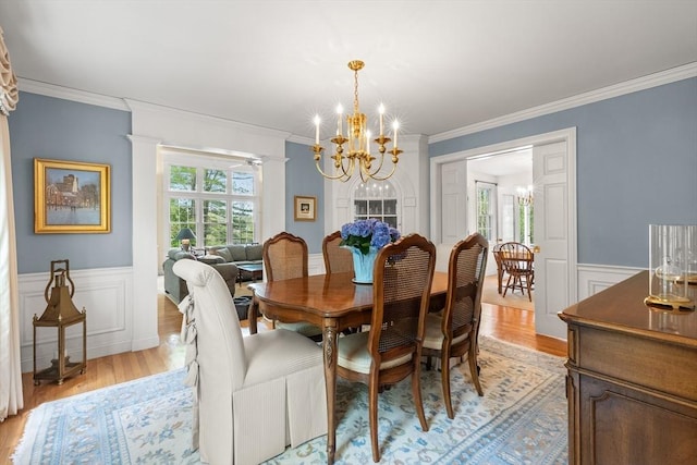 151 River Rd, West Newbury, MA 01985 - dining room featuring a chandelier, light wood-style flooring, ornamental molding, a wainscoted wall, and a decorative wall