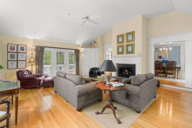 151 River Rd, West Newbury, MA 01985 - living room featuring light wood-style flooring, ceiling fan, a brick fireplace, high vaulted ceiling, and a chandelier