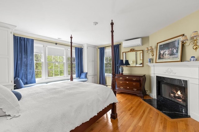 151 River Rd, West Newbury, MA 01985 - bedroom with an AC wall unit, light wood-type flooring, and a fireplace