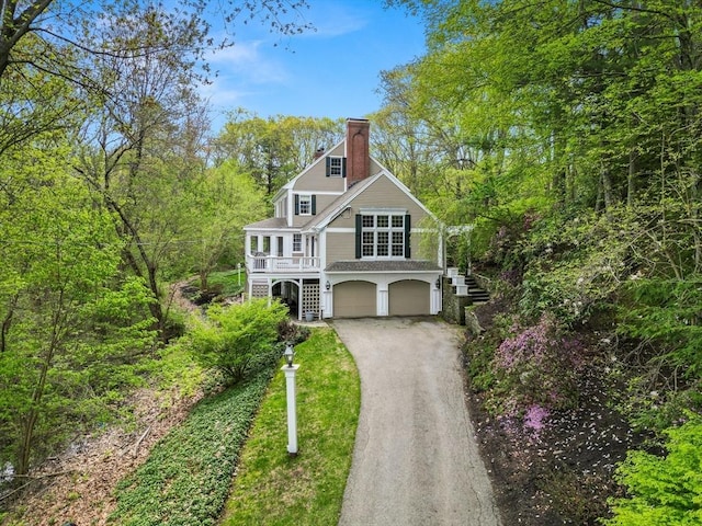 151 River Rd, West Newbury, MA 01985 - view of front of home with stairway, a chimney, a garage, dirt driveway, and covered porch