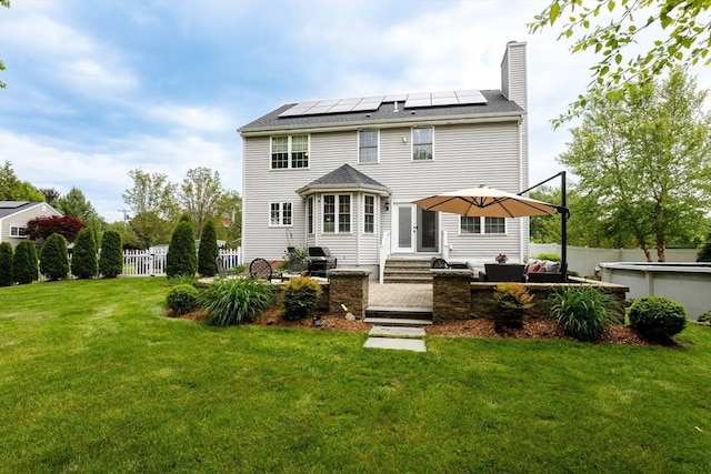1380 Newman Ave, Seekonk, MA 02771 - back of house featuring a chimney, roof mounted solar panels, outdoor lounge area, and entry steps