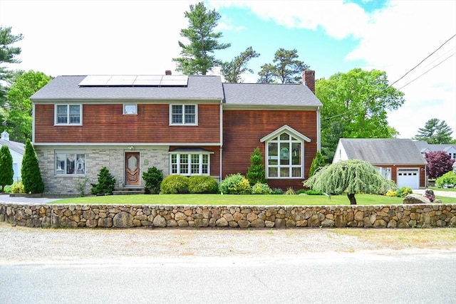 110 Mayflower Ridge Dr, Wareham, MA 02571 - view of front facade featuring a chimney, solar panels, a front yard, a garage, and stone siding