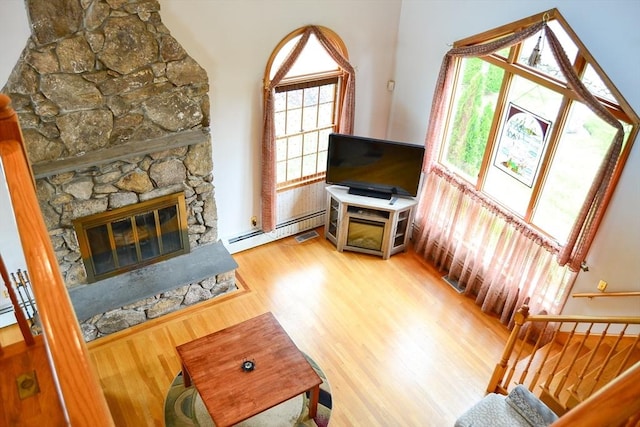 110 Mayflower Ridge Dr, Wareham, MA 02571 - living room with a baseboard radiator, wood finished floors, and a stone fireplace