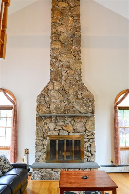 110 Mayflower Ridge Dr, Wareham, MA 02571 - detailed view of baseboard heating, wood finished floors, and a fireplace
