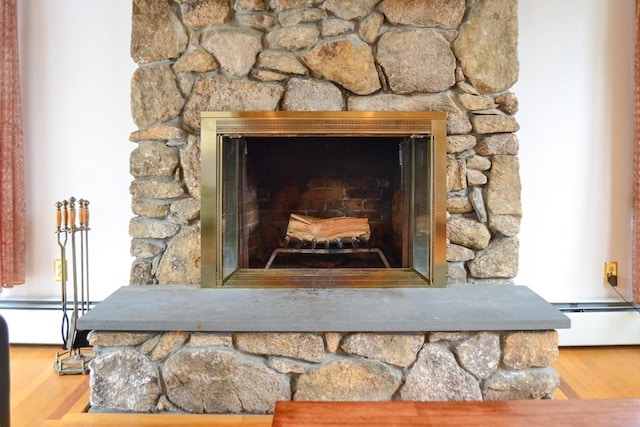 110 Mayflower Ridge Dr, Wareham, MA 02571 - detailed view of a baseboard heating unit, wood finished floors, and a stone fireplace