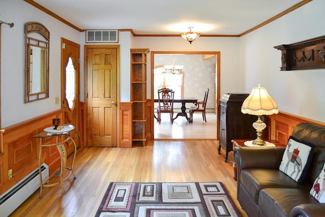 110 Mayflower Ridge Dr, Wareham, MA 02571 - foyer entrance with a baseboard radiator, a chandelier, wainscoting, light wood finished floors, and ornamental molding