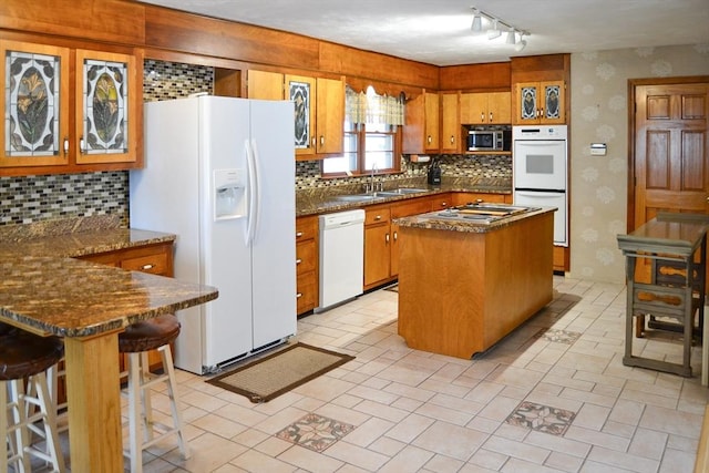 110 Mayflower Ridge Dr, Wareham, MA 02571 - kitchen featuring white appliances, a sink, brown cabinetry, backsplash, and wallpapered walls