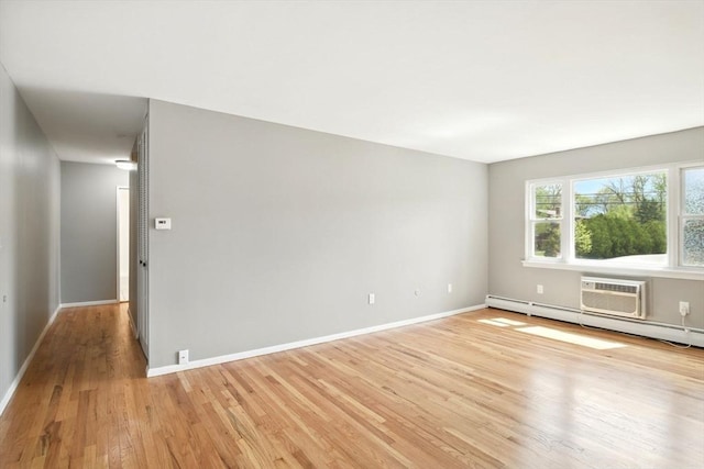 empty room with light wood-style floors, baseboards, and a wall mounted AC