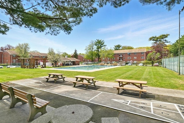 view of community featuring a lawn, fence, a patio, and a pool